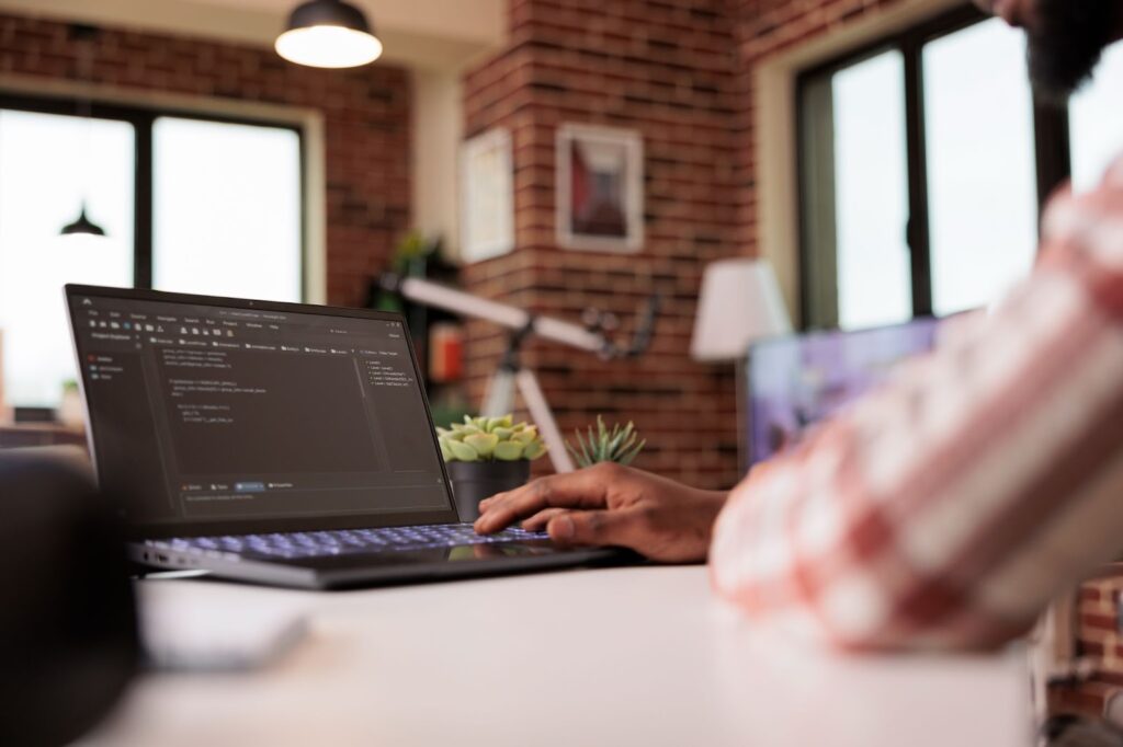 Close up of man working on laptop with code