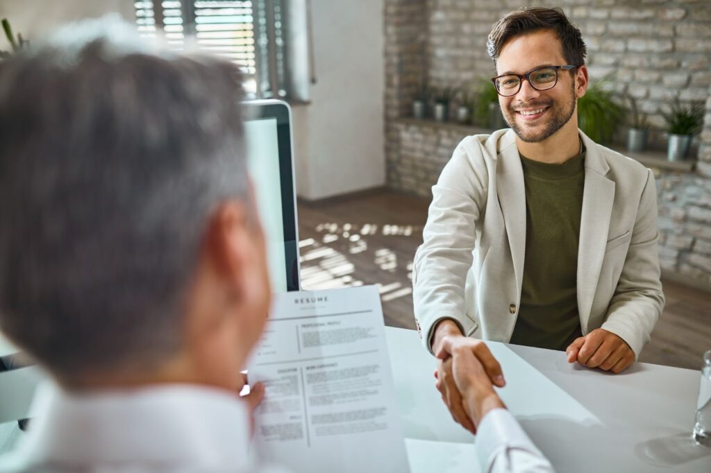 Male candidate greeting a member of human resource team on a job interview in the office