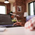 Close up of man working on laptop with code